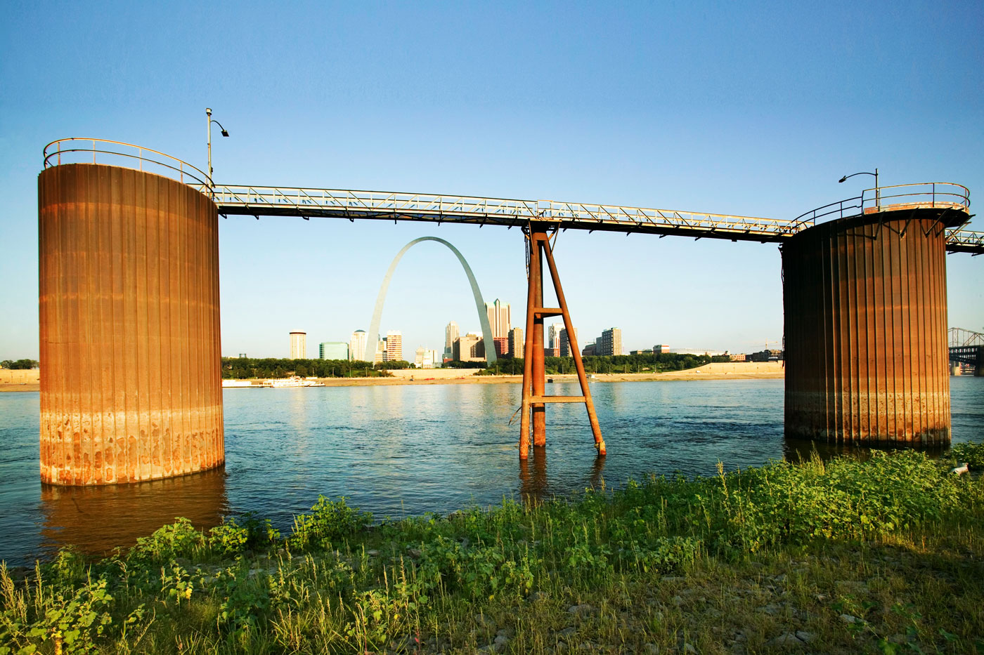 two concrete structures with walkway in between on riverbank